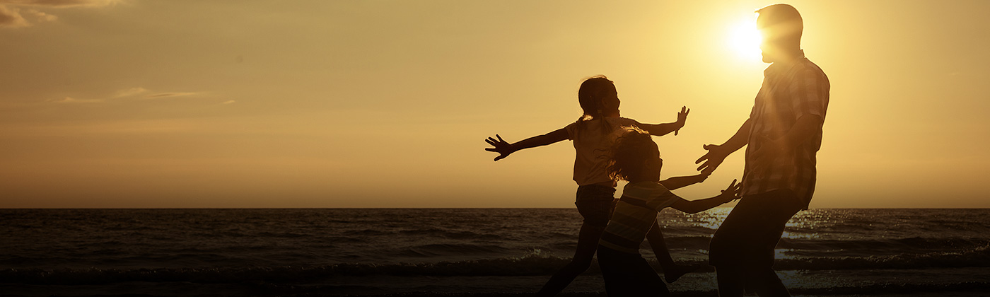 A man playing with his kids on beach